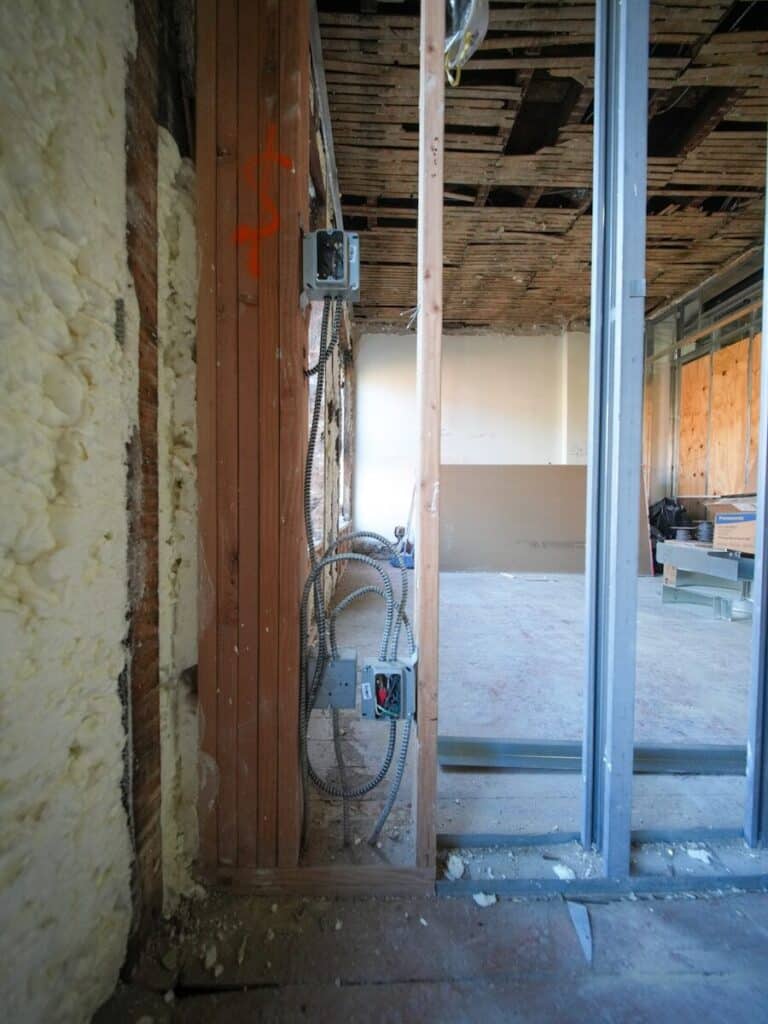 Construction site with exposed wiring and insulation.